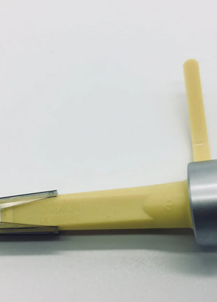 A yellow and silver plastic tool with a clear protective cover on one end and a small black cap on the other, photographed on a plain light background.