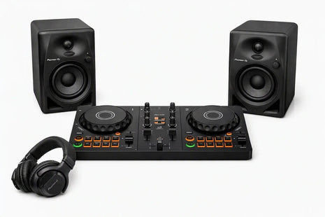 DJ controller bundle featuring a black 4-drum DJ controller in the center, flanked by two matching black studio speakers, with black over-ear headphones in the foreground on a clean white background.